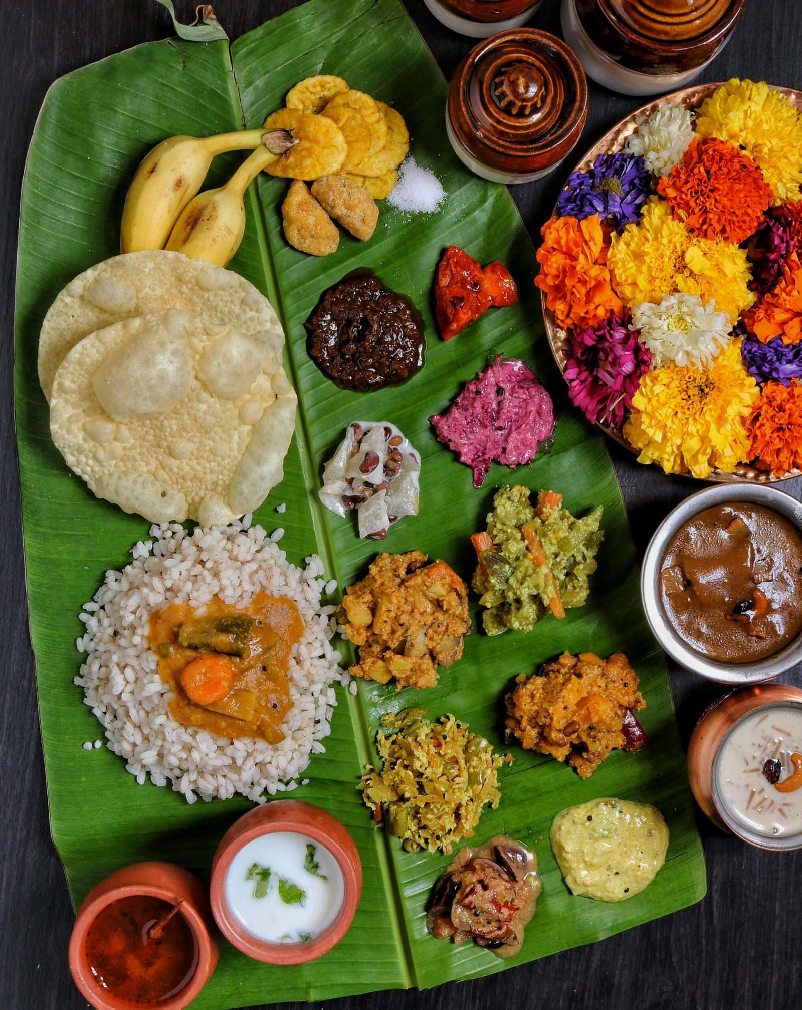 Vibrant South Indian meal served on a banana leaf featuring various dishes and desserts.