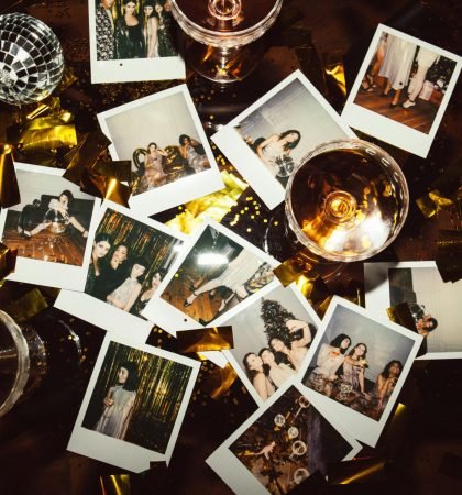 A collection of polaroid photos and glasses on a festive table, capturing party memories.